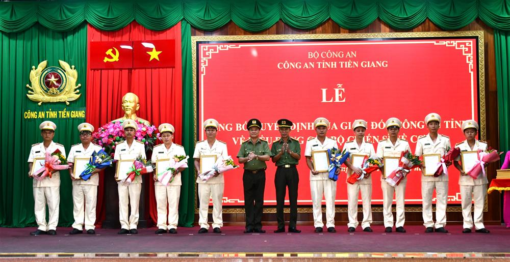 Đại tá Nguyễn Văn Nhựt, Giám đốc Công an tỉnh trao Quyết định và Đại tá Phan Văn Trảng, Phó Giám đốc Công an tỉnh tặng hoa chúc mừng các đồng chí được điều động, bổ nhiệm đến nhận công tác tại Công an cơ sở.