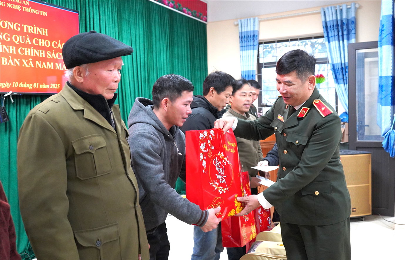Thiếu tướng Dương Văn Tính, Cục trưởng Cục Công nghệ thông tin trao quà tặng các hộ gia đình chính sách.