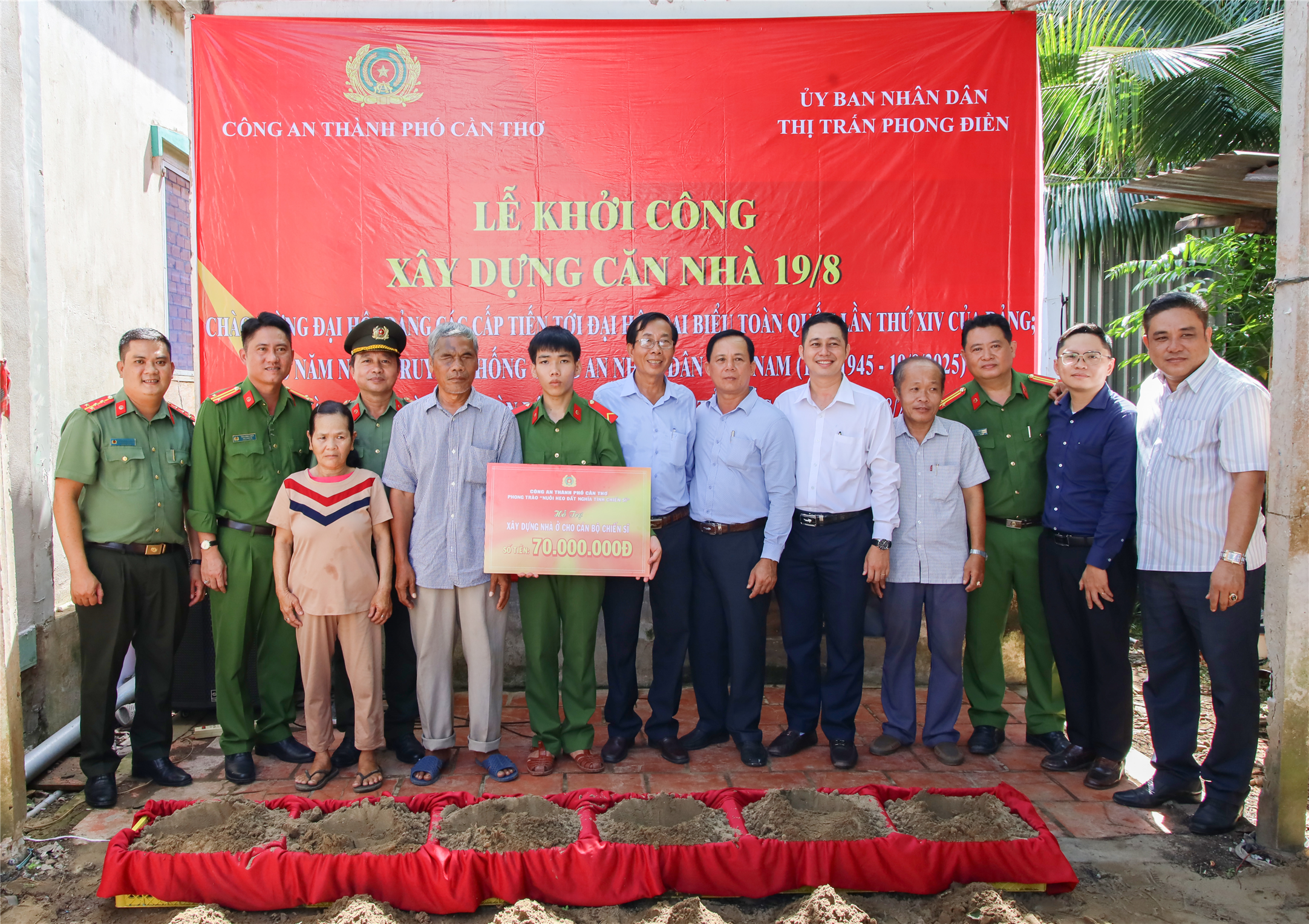 Đại diện Công an thành phố cùng với Ủy ban nhân dân thị trấn Phong Điền trao tặng kinh phí xây dựng nhà tặng gia đình đồng chí Huỳnh Hồng Hà.
