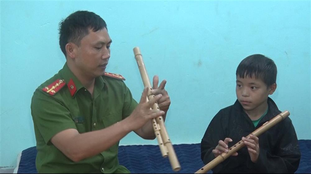 Em Sùng Mí Say được cán bộ Công an xã dạy thổi sao, giữ gìn truyền thống văn hoá của dân tộc.