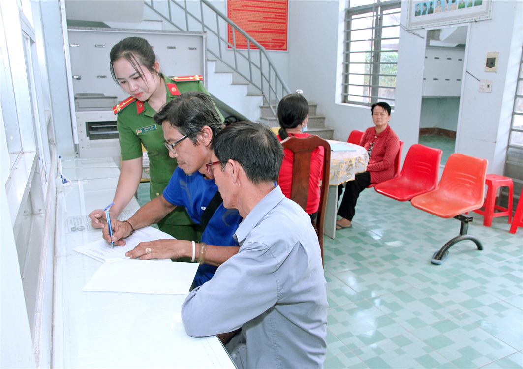 Thượng úy Lê  Ngọc Thu hướng dẫn người dân thực hiện các thủ tục hành chính.
