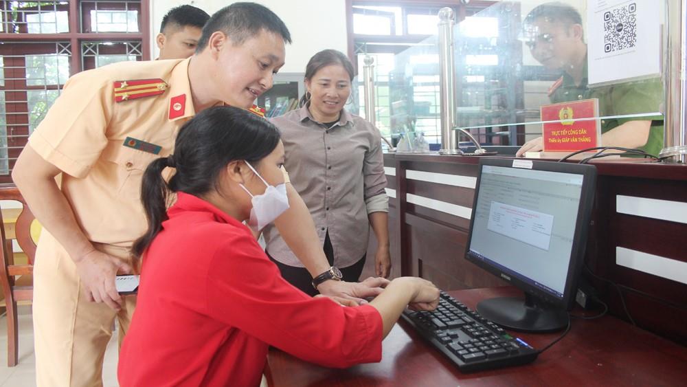 Lực lượng Cảnh sát giao thông hướng dẫn người dân đăng ký xe trên Cổng dịch vụ công.