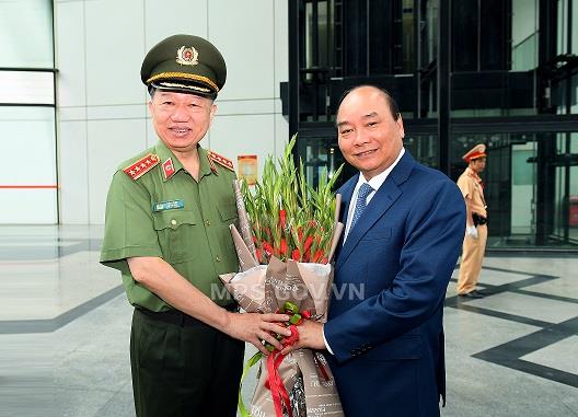 Bộ trưởng Tô Lâm tặng hoa chào mừng Thủ tướng Chính phủ Nguyễn Xuân Phúc đến dự Hội nghị sơ kết công tác công an 6 tháng đầu năm 2020