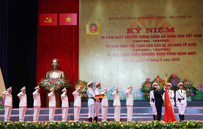 Thay mặt lãnh đạo Đảng, Nhà nước, Thủ tướng Chính phủ Nguyễn Xuân Phúc gắn Huân chương lên lá Cờ truyền thống và trao Bằng Huân chương Quân công hạng Nhất tặng lực lượng Công an nhân dân.