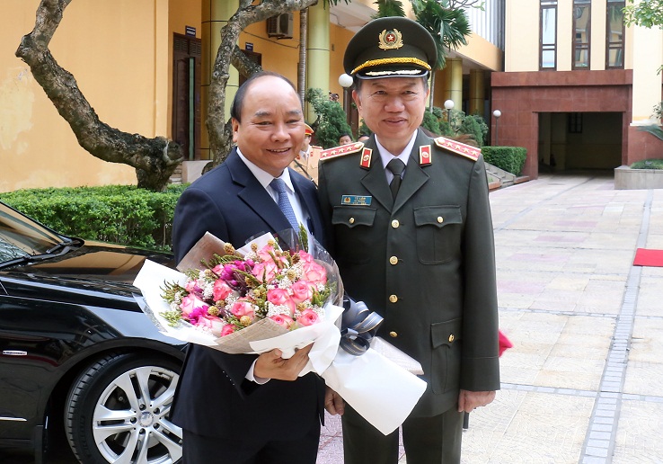Bộ trưởng Tô Lâm tặng hoa Thủ tướng Chính phủ Nguyễn Xuân Phúc.
