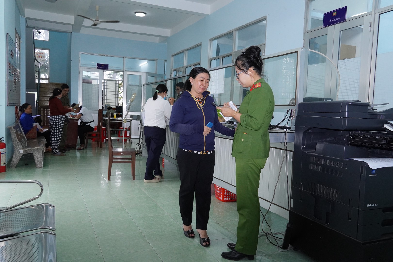 Công an phường Trung An hướng dẫn người dân thực hiện thủ tục hành chính. Ảnh Duy Phương.JPG