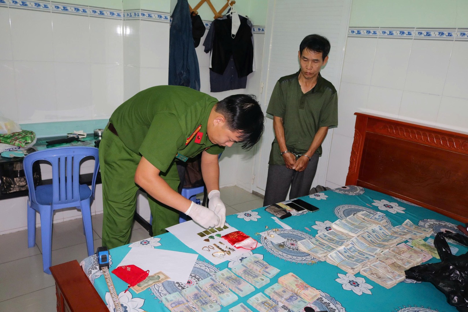 Lực lượng Công an đang kiểm tra tiền và trang sức Mai trộm. Ảnh Phước Thanh.jpg