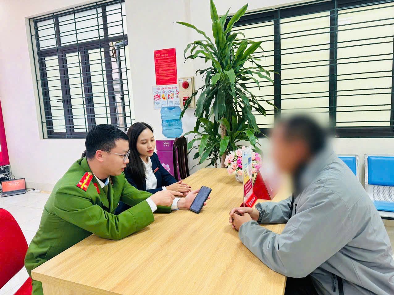 Lực lượng Công an phối hợp Ngân hàng tuyên truyền, giải thích cho anh B.V.N về thủ đoạn của các đối tượng.jpg