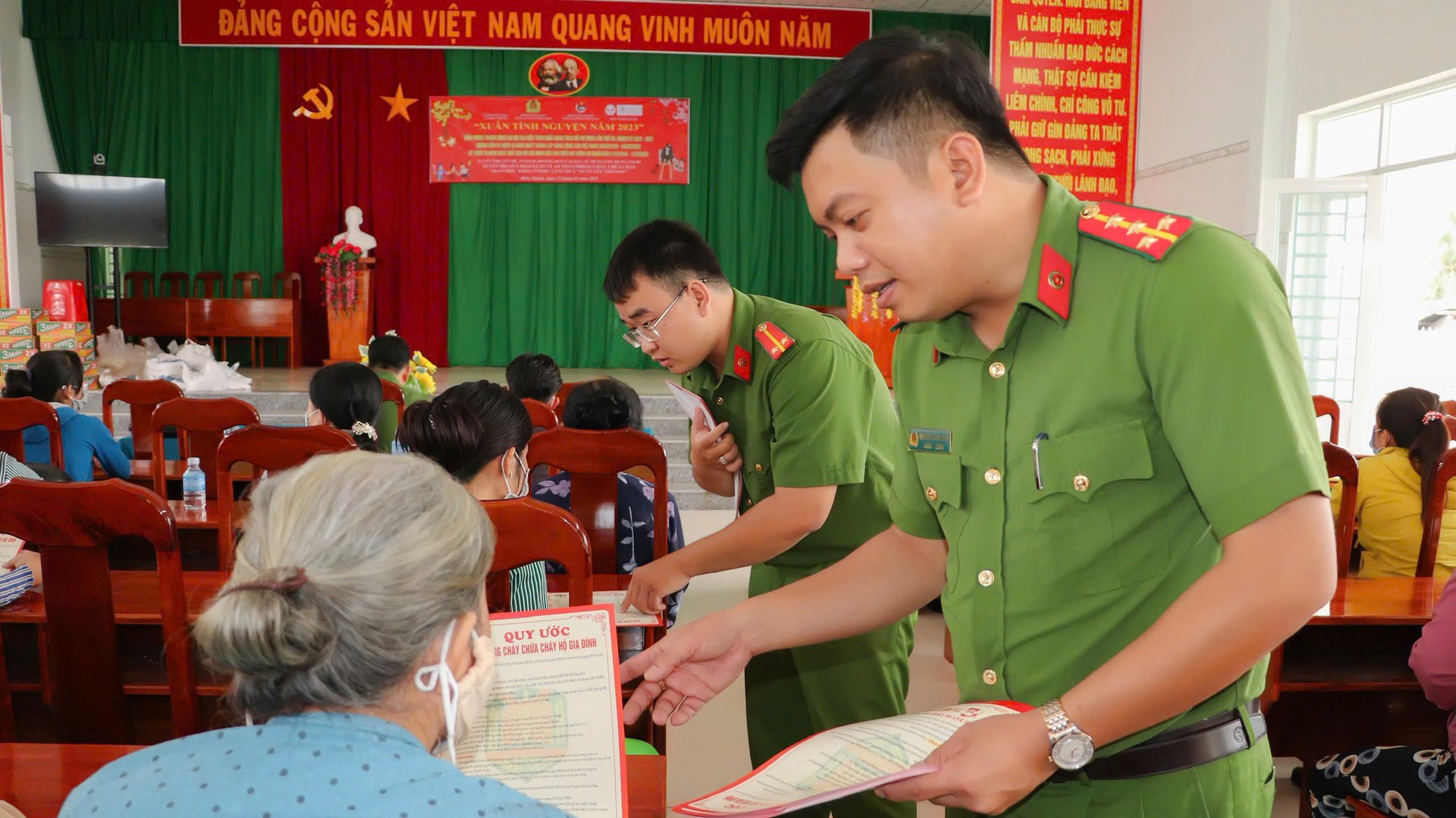 Đại úy Nguyễn Trường Xuân, Bí thư Đoàn cơ sở Phòng Cảnh sát PCCC và CNCH, Công an tỉnh Vĩnh Long phát tờ rơi tuyên truyền pháp luật cho hộ gia đình.jpg