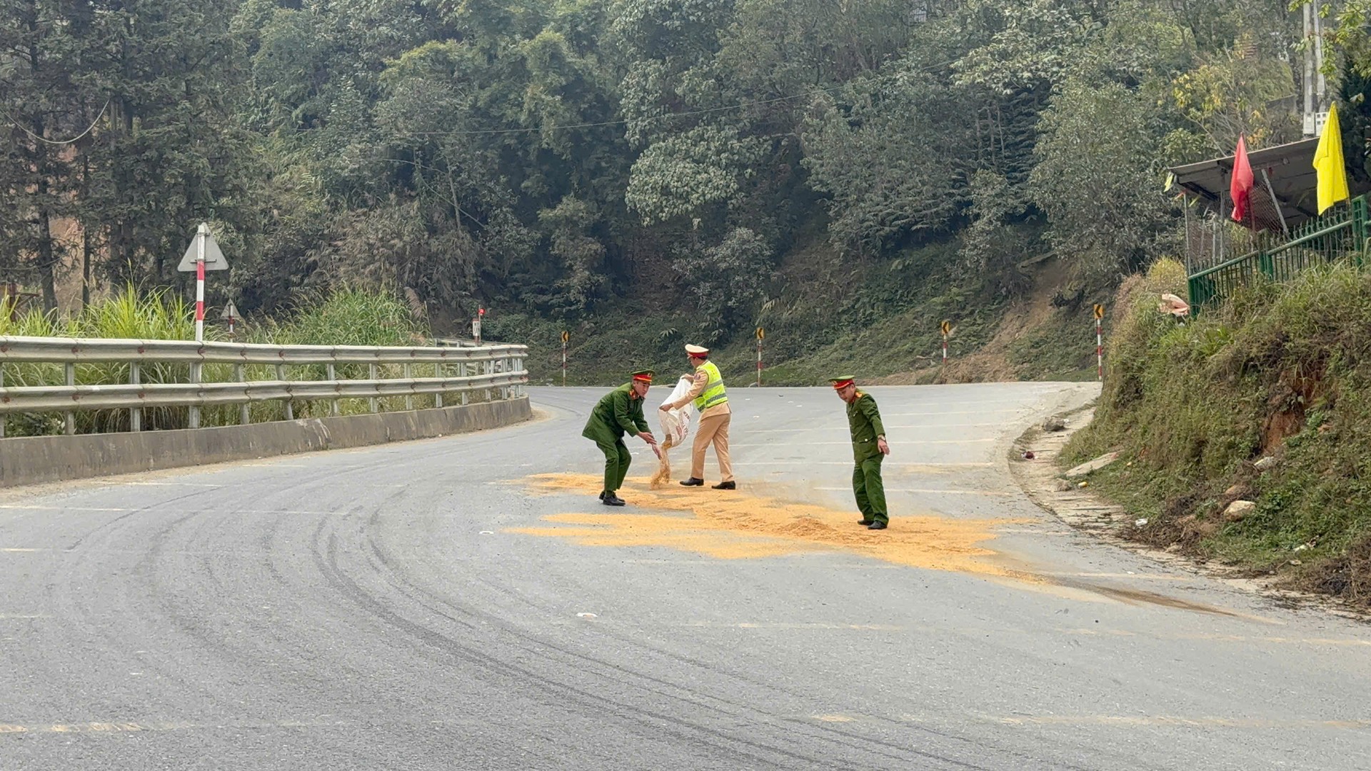 CSGT và Công an xã Tả Phìn dùng trấu dải lên đoạn đường bị dầu loang.jpg