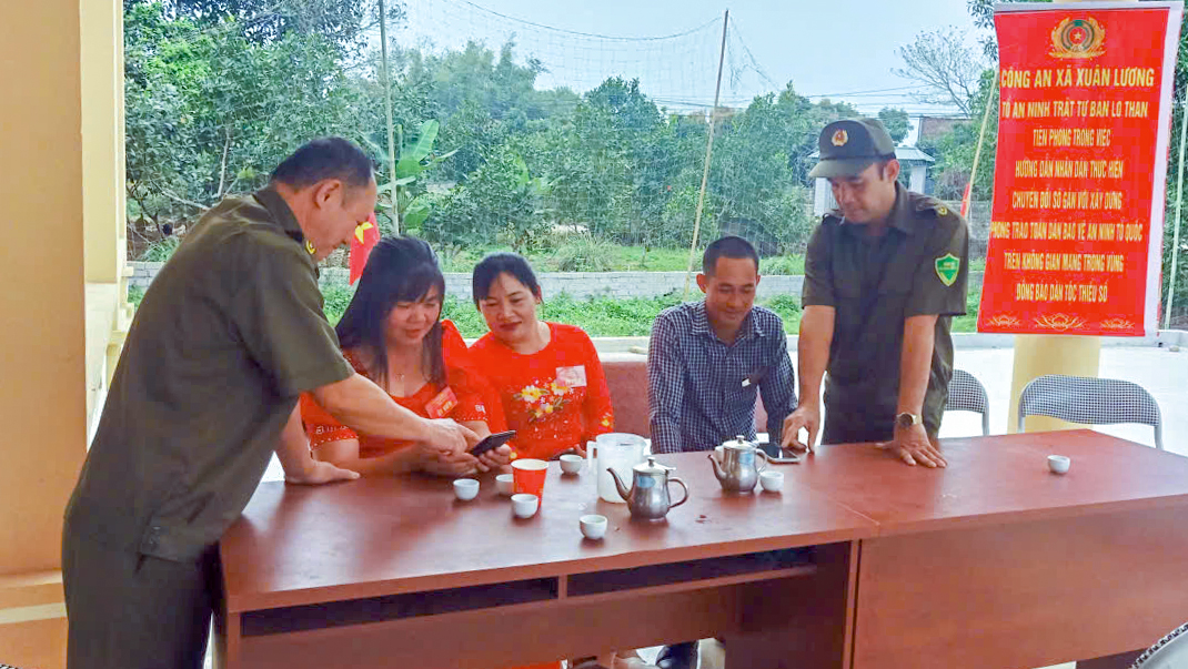 Cán bộ Công an xã và thành viên Tổ bảo vệ ANTT bản Lò Than, xã Xuân Lương hướng dẫn người dân thực hiện các thủ tục hành chính thông qua môi trường mạng.jpg