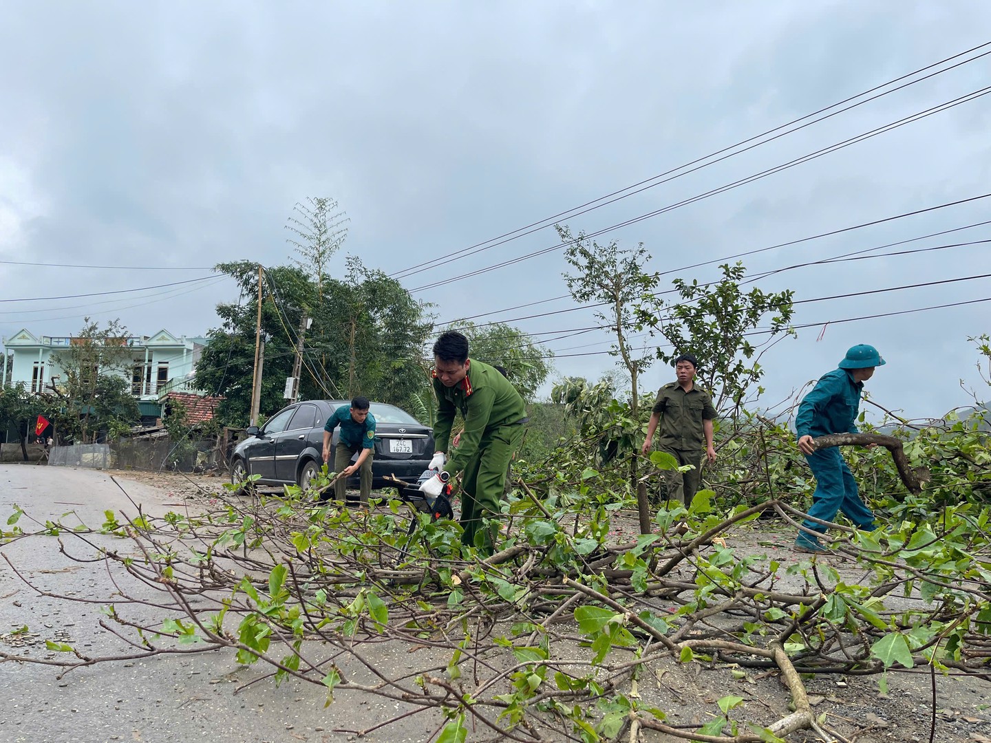 Nhiều cây lớn bị đổ vào nhà dân và đường giao thông, lực lượng Công an xã đã kịp thời xử lý đảm bảo giao thông an toàn thông suốt.jpg