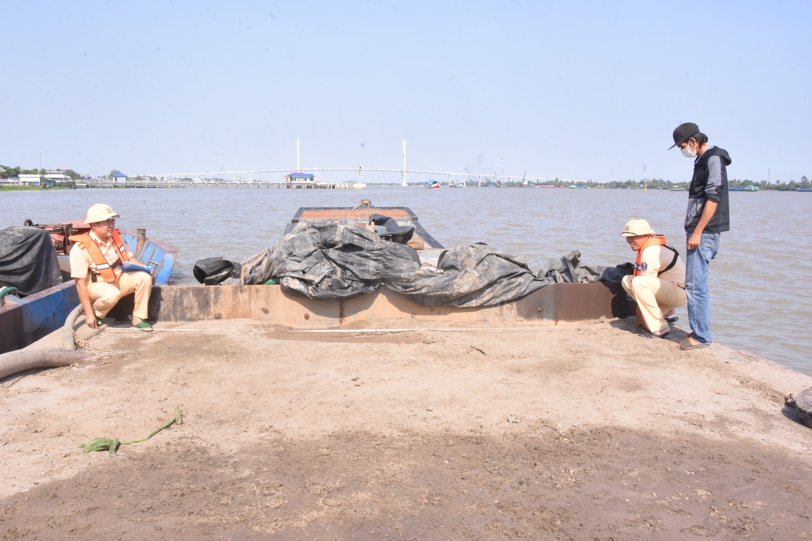 Lực lượng Cảnh sát giao thông xử lý phương tiện vận chuyển cát không rõ nguồn gốc tại thủy phận phường Đạo Thạnh. Ảnh Lê Hoài.JPG