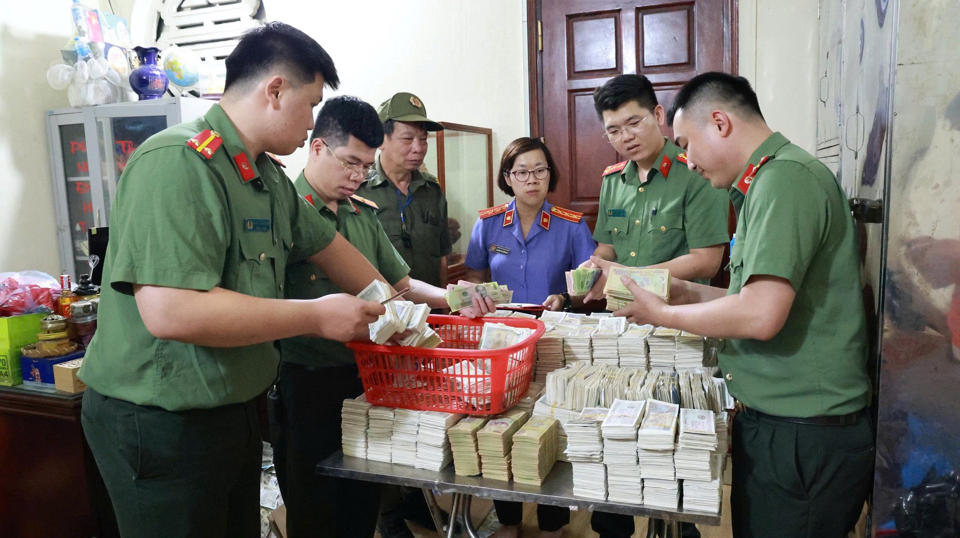 Ảnh 2. Lực lượng Công an phối hợp với các lực lượng tiến hành khám xét, thu thập tài liệu, tiền mặt phục vụ công tác điều tra.jpg
