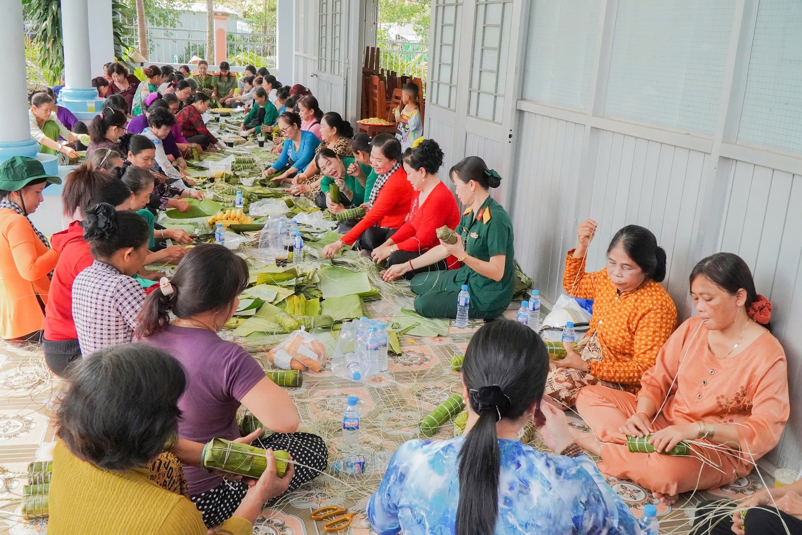 Phụ nữ Công an Quân sự cùng nhân dân xã Ngãi Tứ gói bánh tét trong dịp Tết Quân Dân năm 2026.jpg