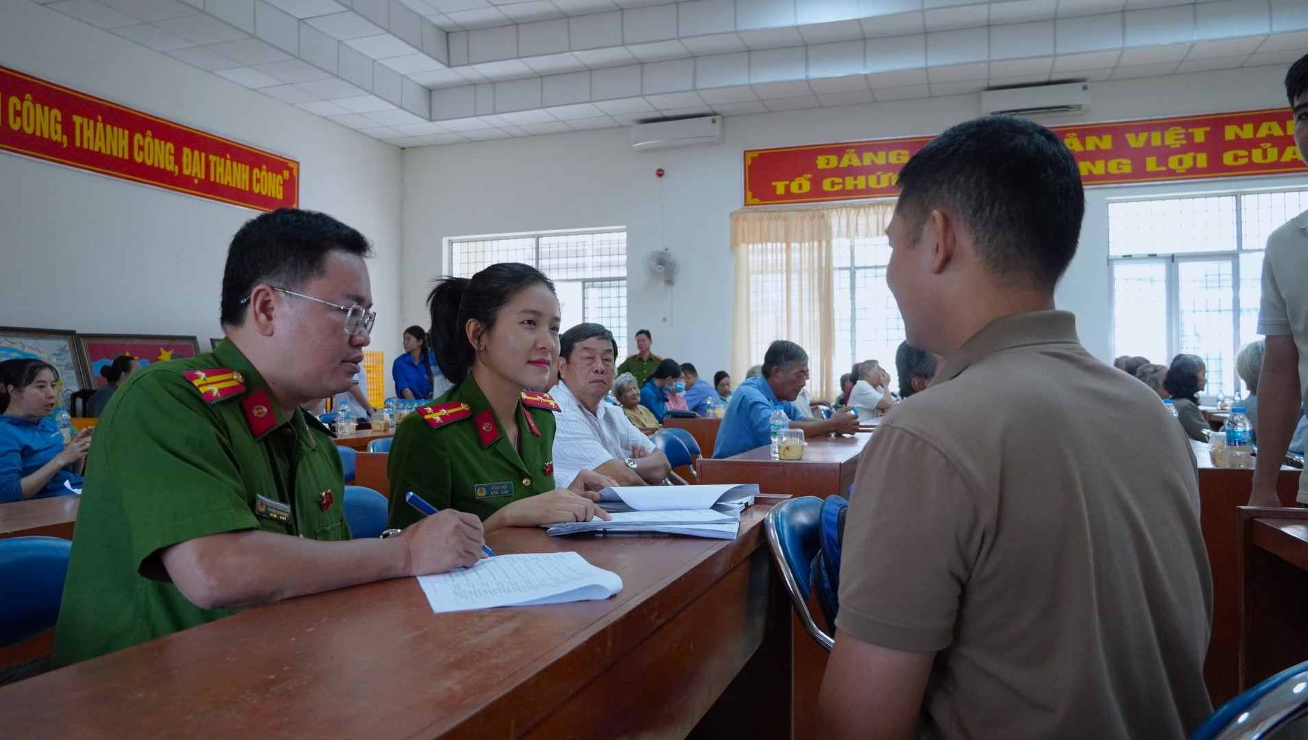 Công an phường Mỹ Tho tận tình hướng dân thân nhân liệt sĩ thủ tục thu nhận sinh phẩm ADN. Ảnh Duy Phương.JPG