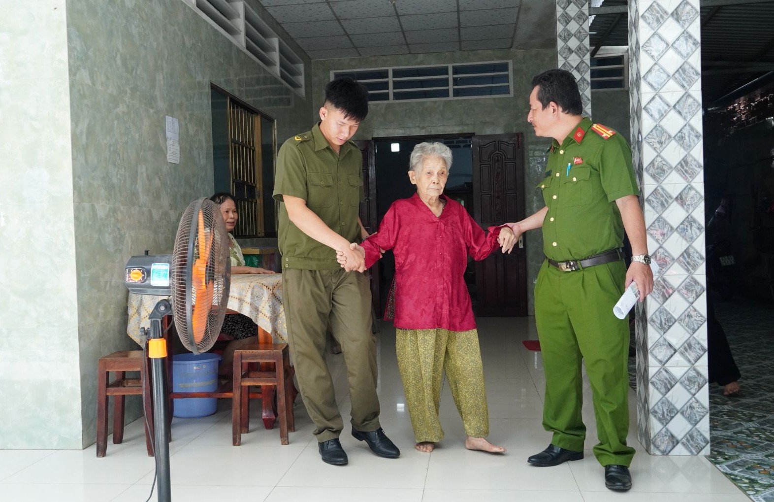 Công an xã Châu Thành hỗ trợ thân nhân liệt sĩ đến điểm thu nhận sinh phẩm ADN. Ảnh Duy Phương.JPG