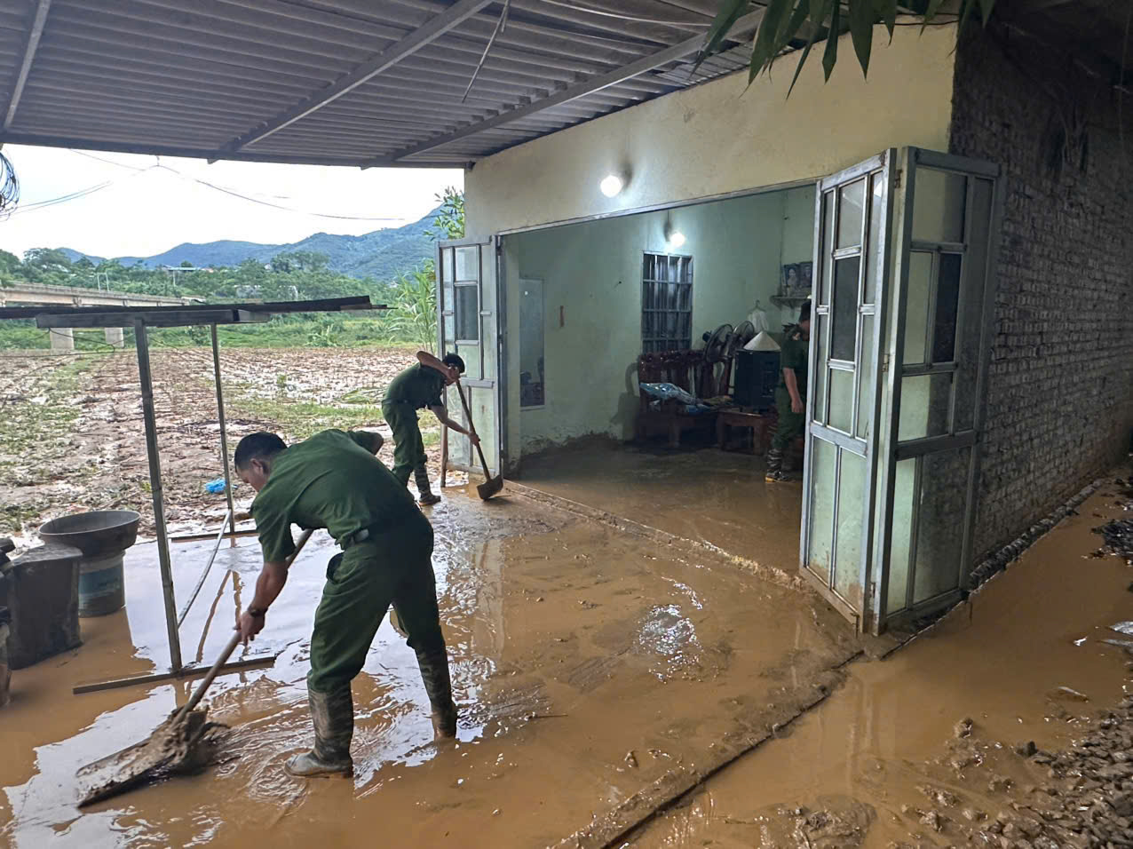 Công an xã Liên Sơn giúp nhà dân bị đất sạt tràn vào nhà.jpg