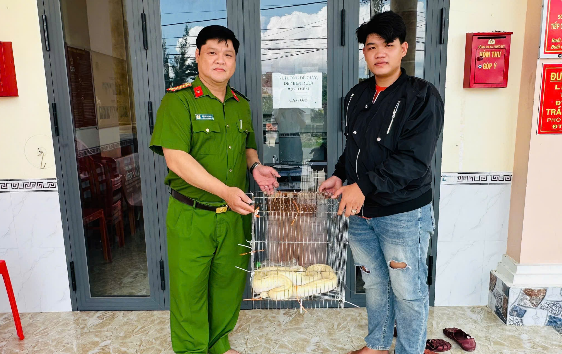 Em Đinh Văn Chính giao nộp cá thể trăn gấm cho Công an xã Hưng Mỹ.png