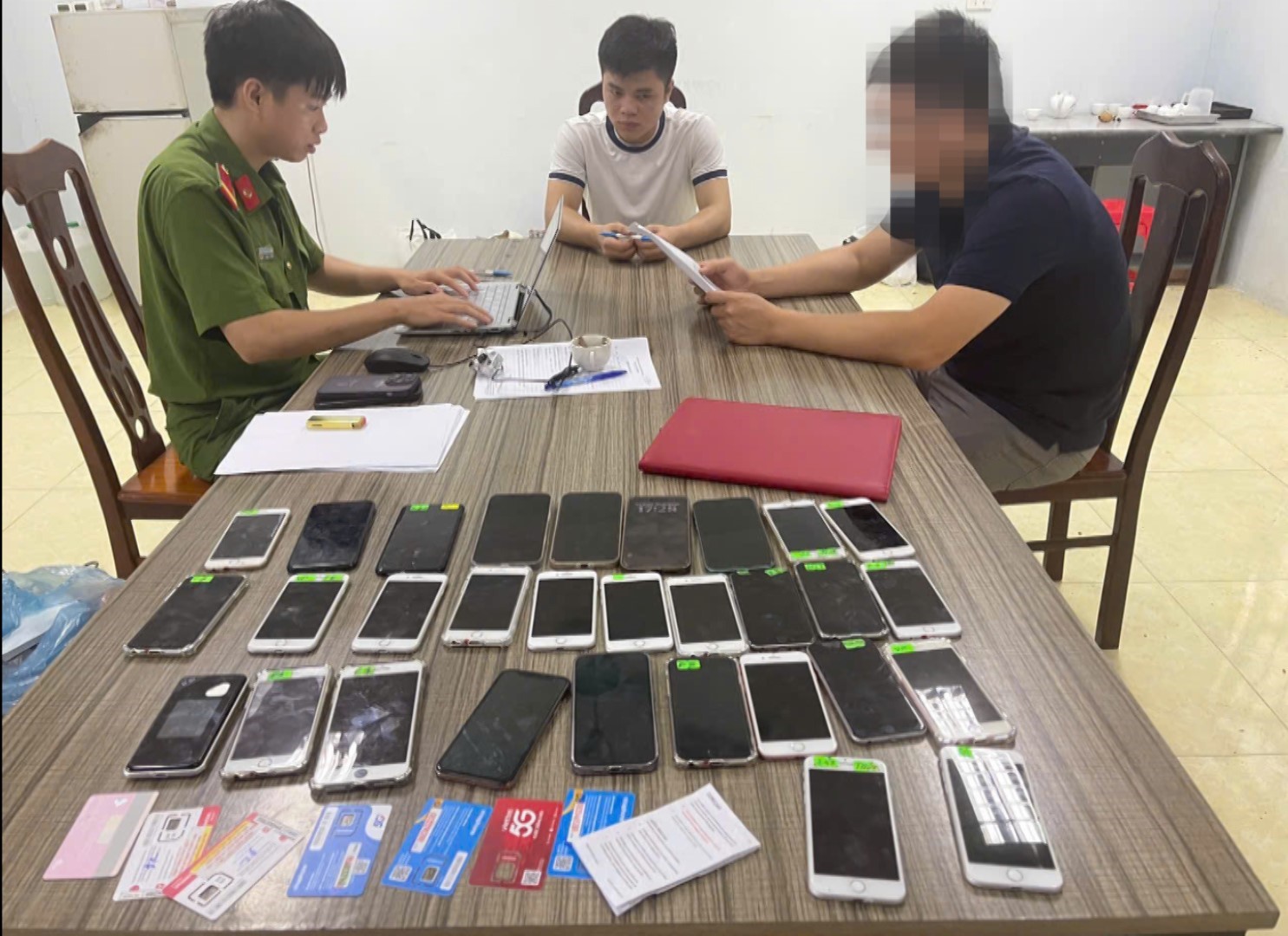 Ảnh 5. Đối tượng Cao Văn Dương (áo trắng) và một số vật phẩm của dự án.jpg