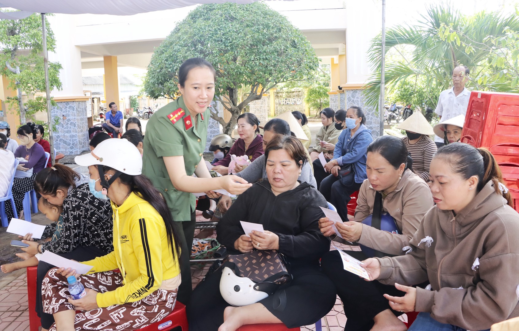 Cán bộ Phòng An ninh mạng phát tờ rơi cho phụ huynh học sinh về biện pháp bảo vệ trẻ em trước các thủ đoạn thao túng “bắt cóc online”.JPG