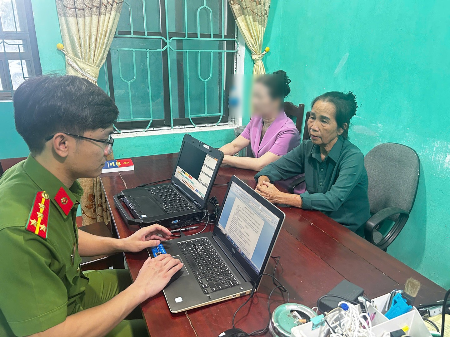 Cơ quan Cảnh sát điều tra làm việc với Hoàng Thị Vui để làm rõ hành vi chiếm đoạt tiền của 15 người dân tại xã Thượng Long với tổng số tiền hơn 2,4 tỷ đồng.jpg