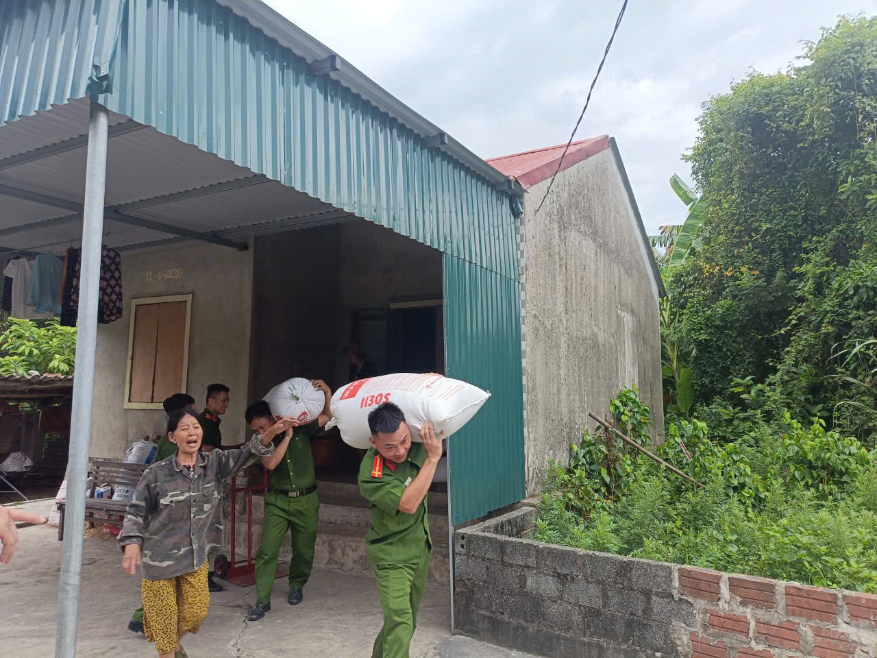 Lực lượng CA giúp dân kê dọn nông sản lên nơi an toàn.jpg