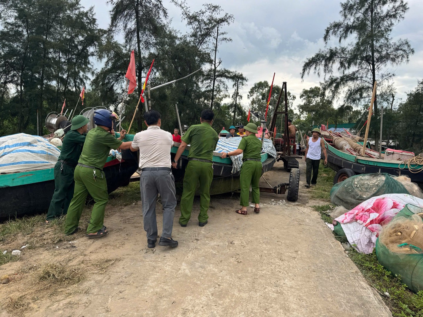 Lực lượng CA giúp dân đưa tàu thuyền lên nơi trú ẩn an toàn.jpg
