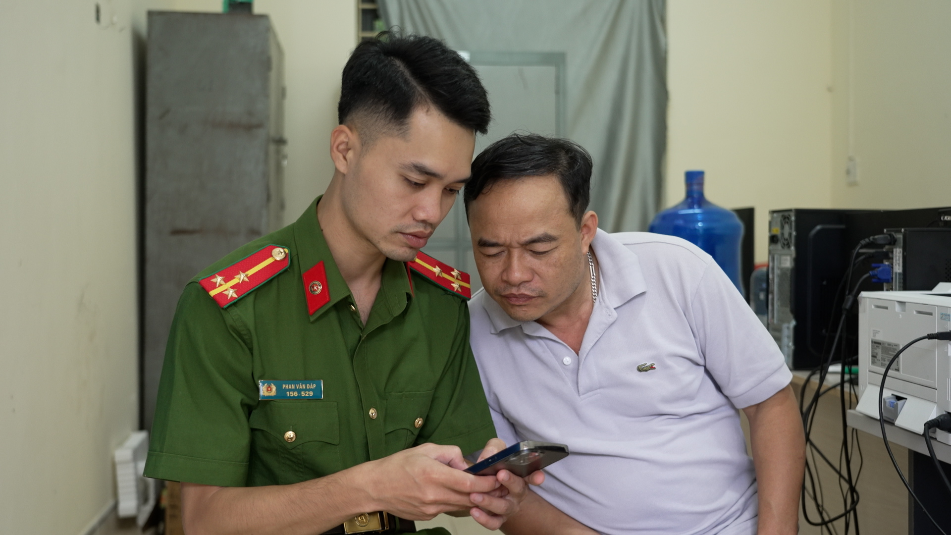 Cán bộ Công an xã Trà Lĩnh hướng dẫn người dân giải quyết thủ tục đổi giấy phép lái xe trên VNeID.jpg