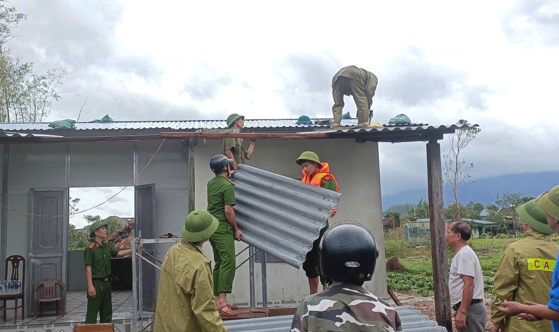 Công an xã Kỳ Hoa phối hợp Tổ ANTT thôn Trường Lạc  gia đình bà Đào Thị Nước - Vợ liệt sỹ thôn Trường Lạc lợp lại mái nhà.JPG