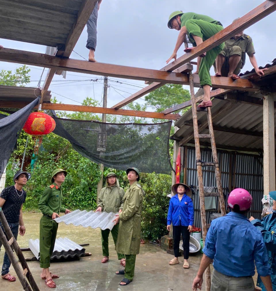 Thượng uý Trần Quảng Đại cùng cán bộ CA xã hỗ trợ nhân dân khắc phục hậu quả mưa bão.jpg