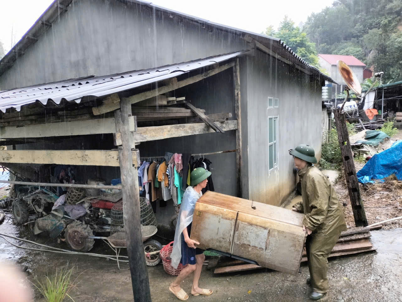 Công an xã Canh Tân hỗ trợ người dân vận chuyển đồ đạc lên vị trí cao, bảo đảm an toàn trong mưa lũ.jpg