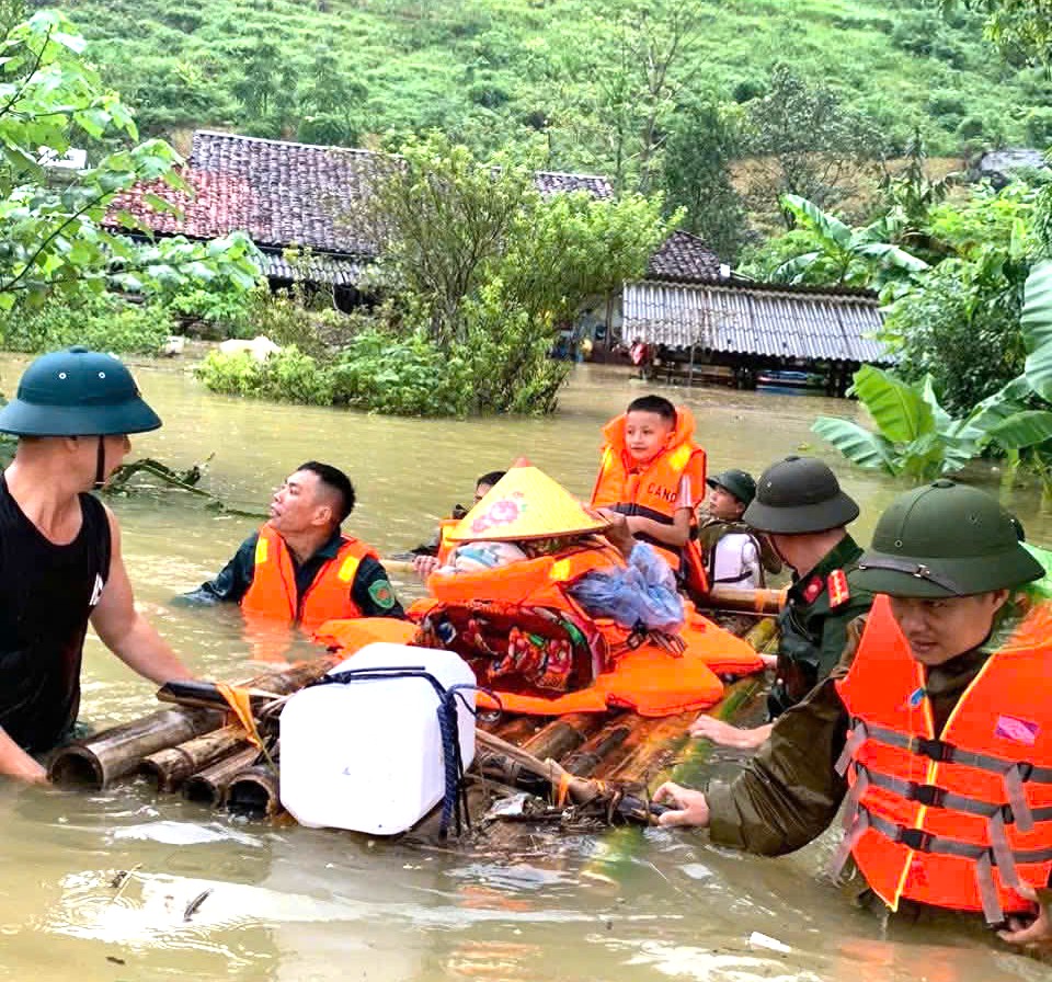 Công an xã Nguyên Bình hỗ trợ cụ bà Triệu Dào Lẩy, 102 tuổi, sơ tán khỏi khu vực ngập sâu.jpg