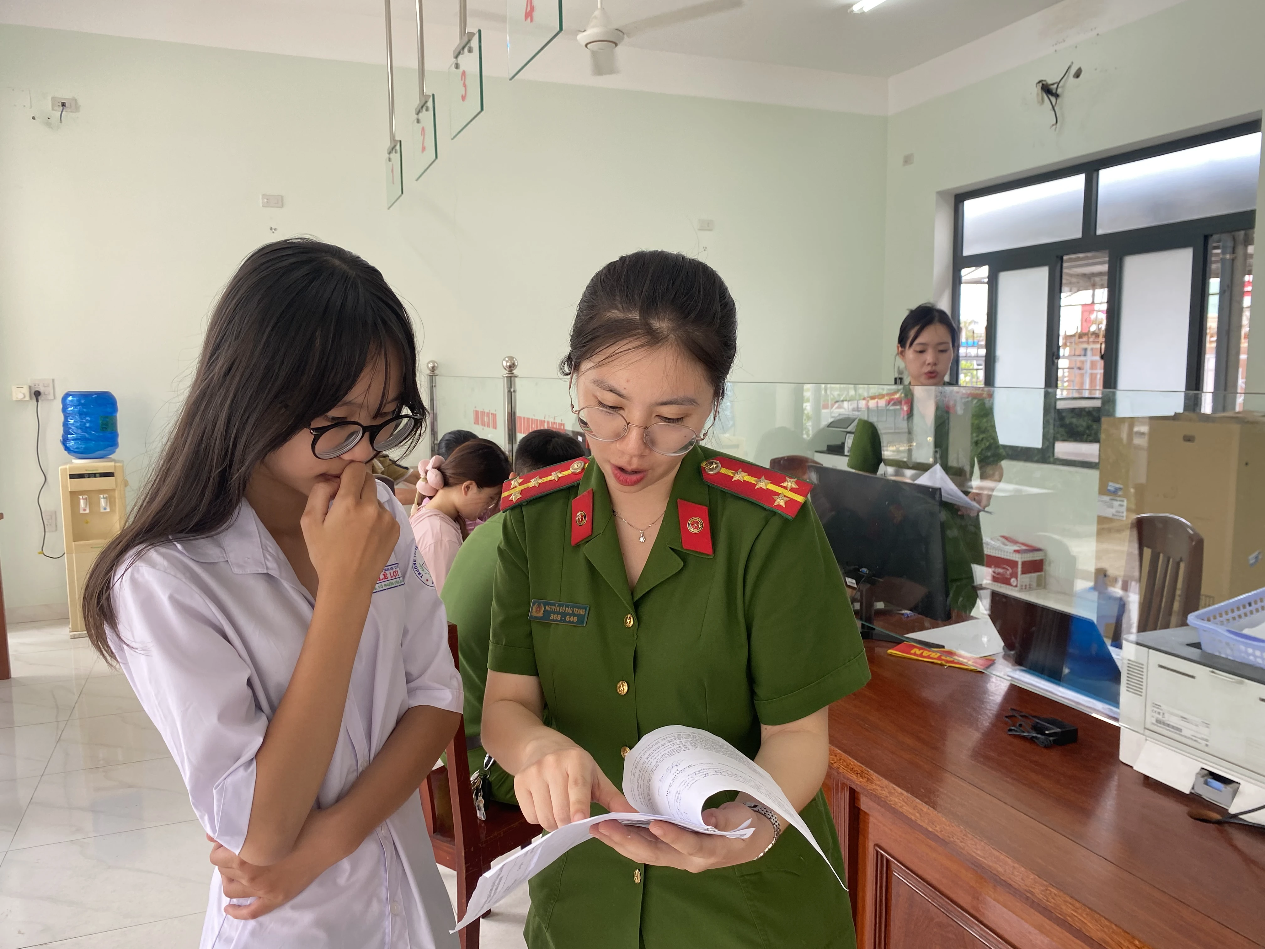 Cán bộ Tổ Cảnh sát khu vực, CA phường Quy Nhơn Nam, tỉnh Gia Lai hướng dẫn công dân thực hiện thủ tục hành chính.jpg