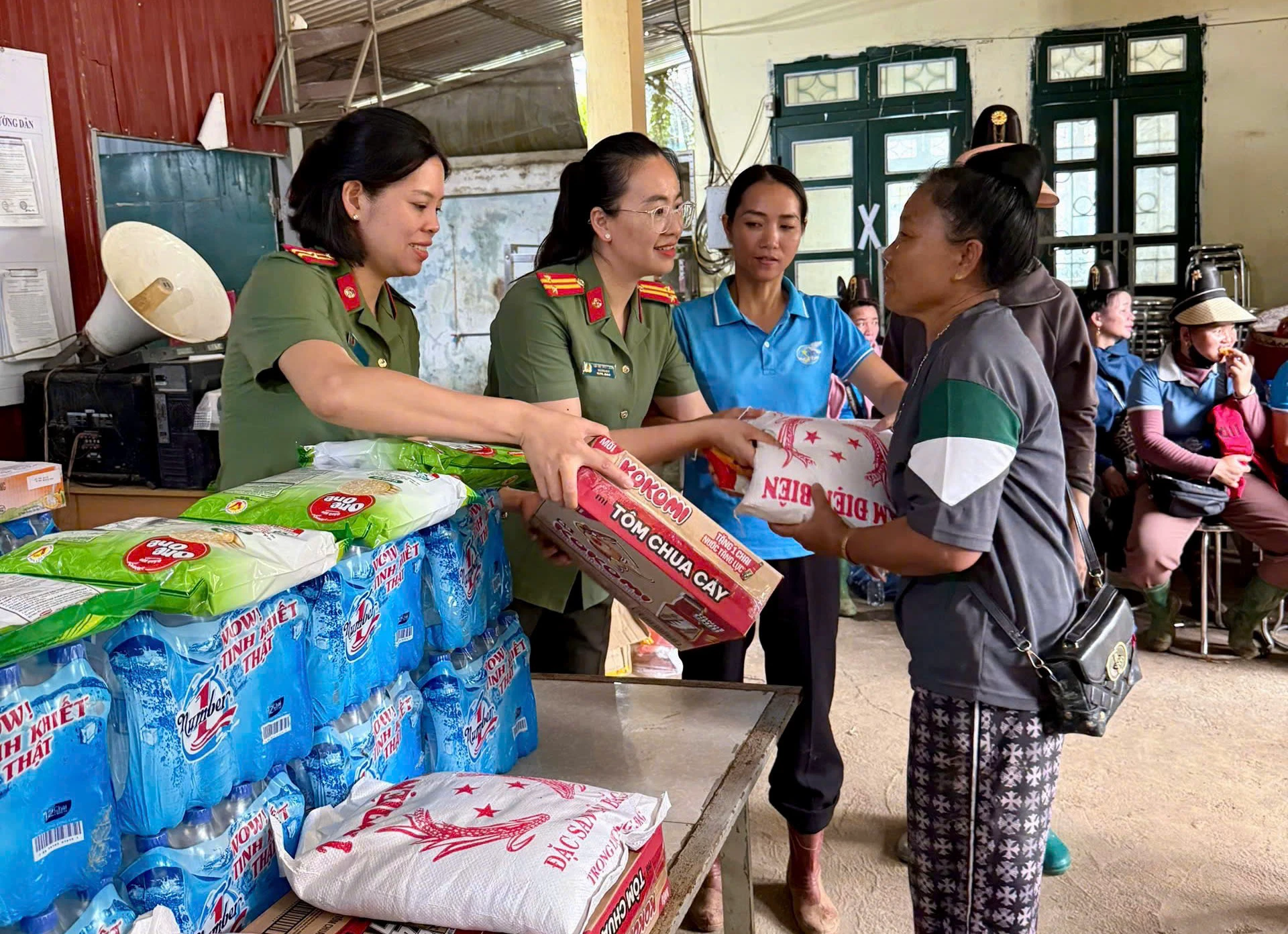 Cán bộ hội viên Hội phụ nữ Công an Điện Biên trao các nhu yếu phẩm cho nhân dân bụ thiệt hại do mưa lũ.jpg