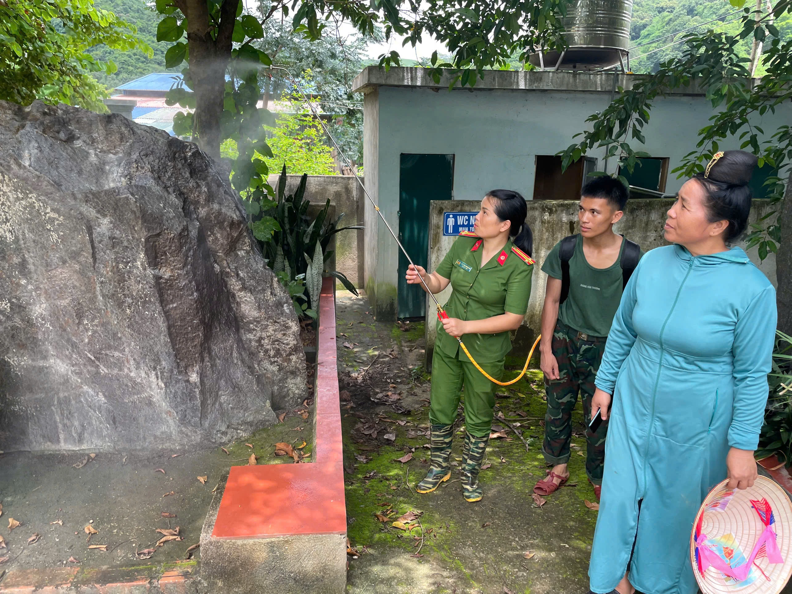 Cán bộ hội viên Hội phụ nữ Công an Điện Biên hướng dẫn nhân dân phun thuốc khử khuẩn bằng chế phẩm sinh học.jpg