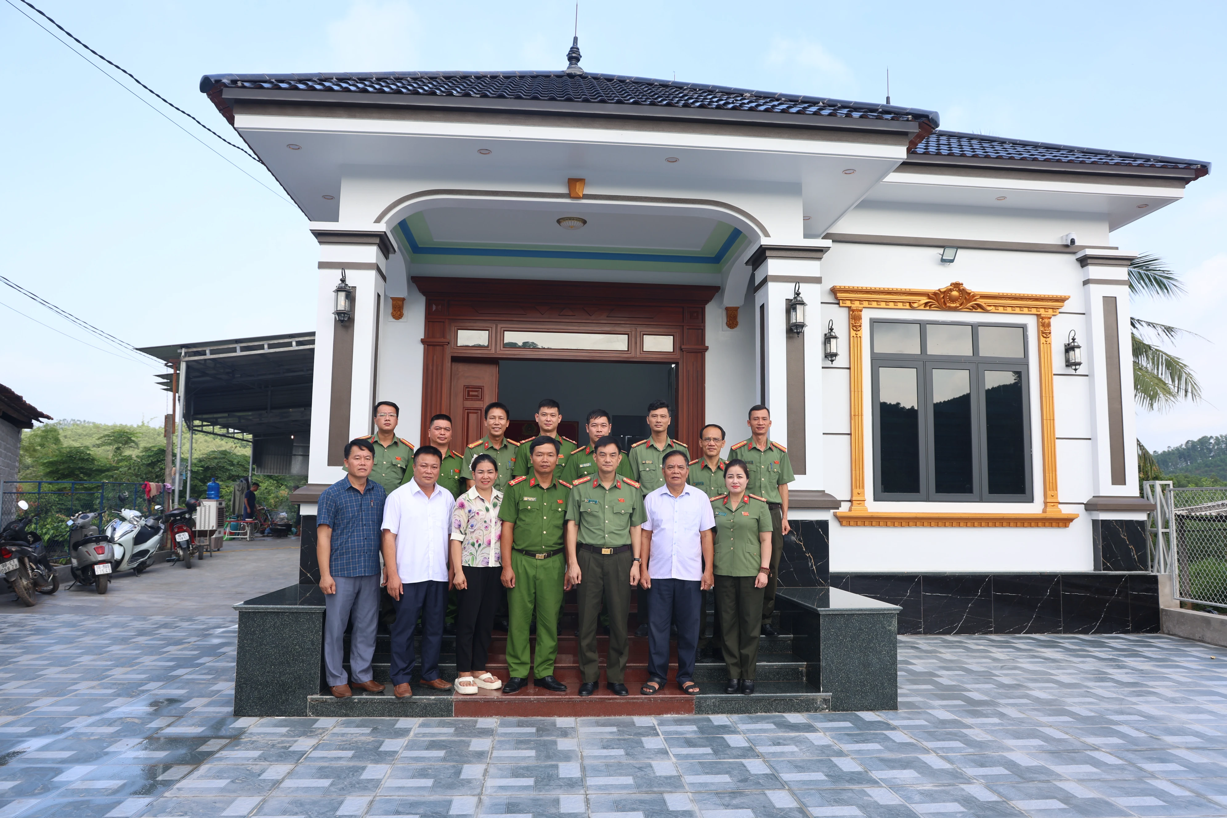 Các đại biểu chụp ảnh lưu niệm cùng gia đình Đại úy Ngô Quảng Nam tại ngôi nhà mới.JPG